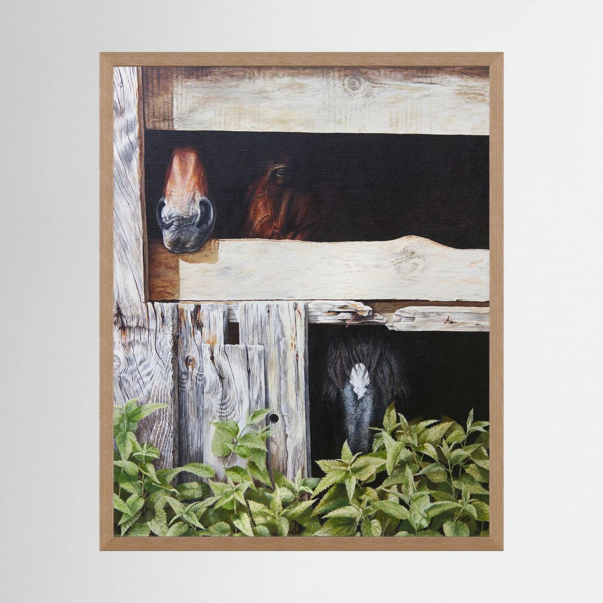 A framed (nature oak) art paper print depicting horses in rustic wooden stalls with green foliage at the bottom, shown against a light gray background.