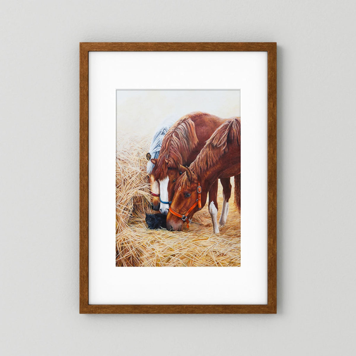 A framed (dark oak) paper art print with a white passepartout featuring a painting of three young horses and a black cat displayed against a neutral light gray background.