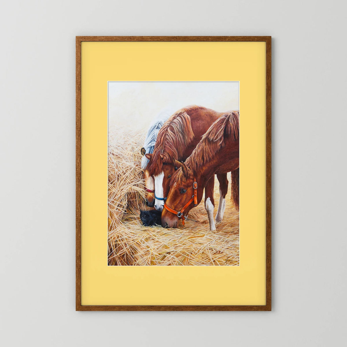 A framed (dark oak) paper art print with a yellow passepartout featuring a painting of three young horses and a black cat displayed against a neutral light gray background.