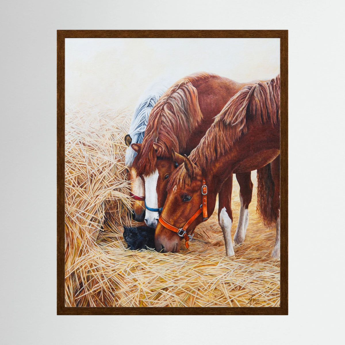 A framed (dark oak) paper art print of two chestnut horses, one buckskin horse sniffing a black cat on a bed of golden hay, presented on a light gray background.