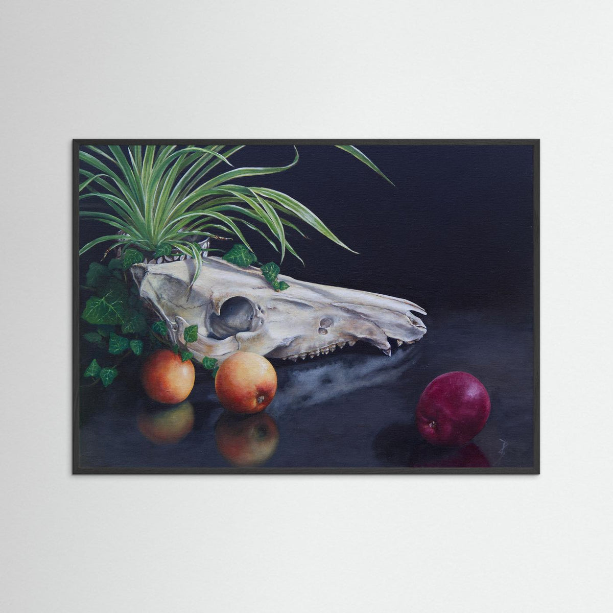 A framed (black frame) still life painting on a light gray wall, depicting a white animal skull with green leaves and plants, and a red apples on a dark reflective surface.